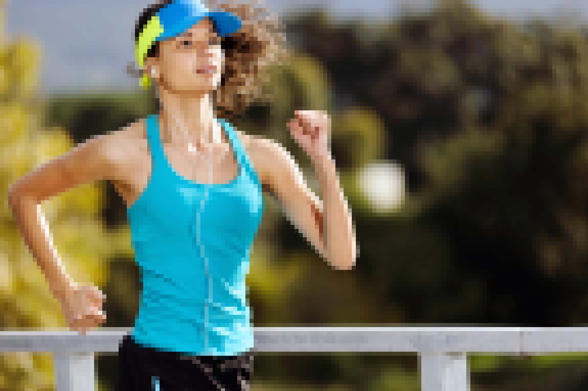 Portrait of a woman athlete runner training outdoors with cap and headphones listening to music. endurance sport.